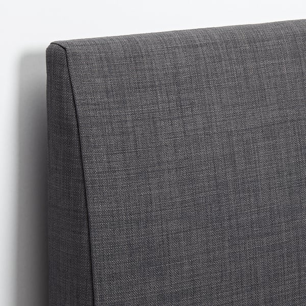 Upholstered headboard in dark grey fabric with clean lines, showing high-quality stitching and smooth texture.