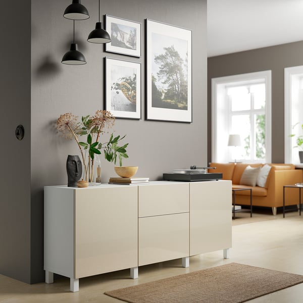 Modern living room with BESTÅ sideboard, art, rug, and orange couch.