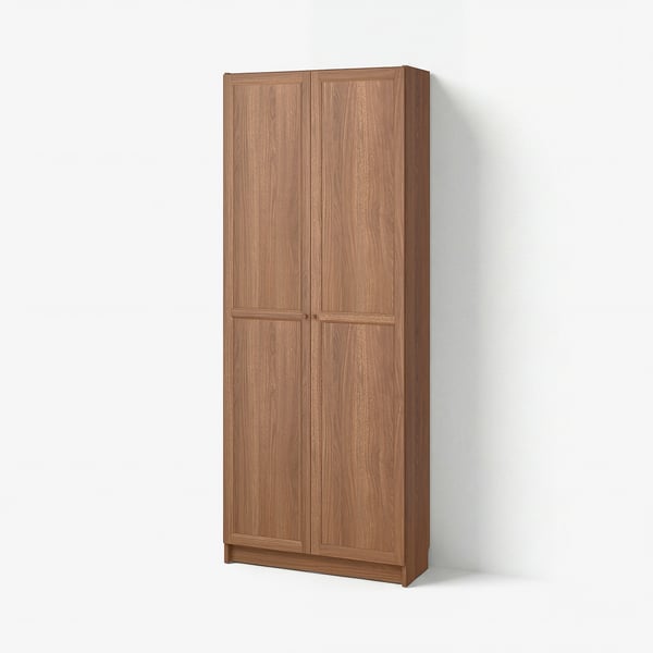 BILLY light brown wooden bookcase with two closed doors. Simple, rectangular design with vertical panels.