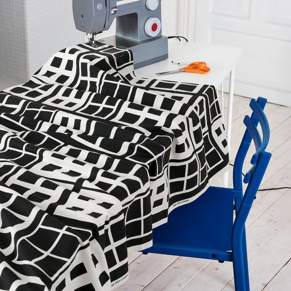 A sewing table with a patterned fabric, scissors, and a sewing machine.