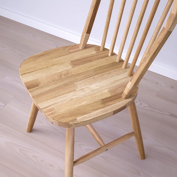 Wooden chair close-up. Light tan finish, smooth seat & slatted back. Crafted from solid acacia wood, showcasing fine grain patterns.