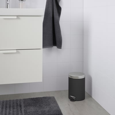 EKOLN grey bin, sleek design, fits small spaces, includes a handle, now near a bathroom sink.