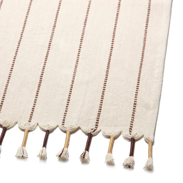 Table runner with woven stripes and fringe tassels, high-quality cotton and jute blend.