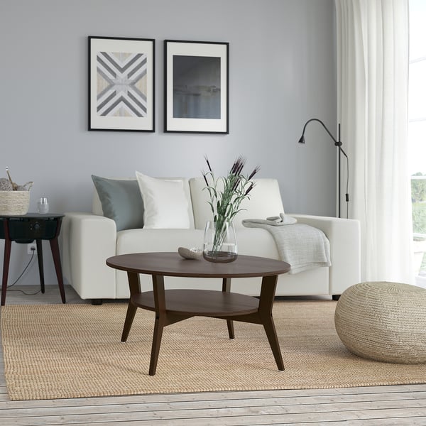 Modern living room with JAKOBSFORS coffee table, flowers, and wall art.
