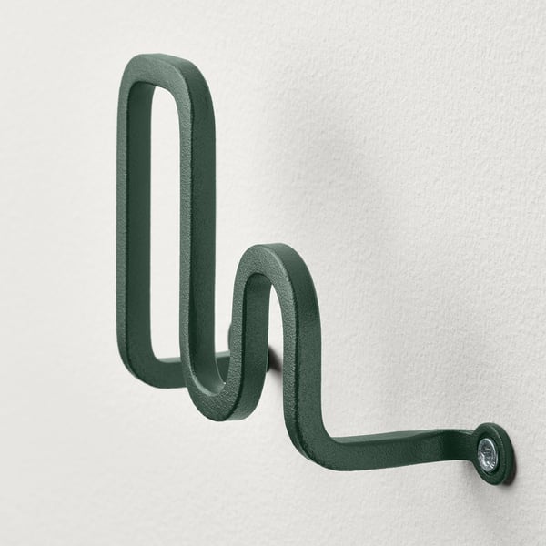 Decorative green metal hook mounted on wall. Modern design, durable powder coating.