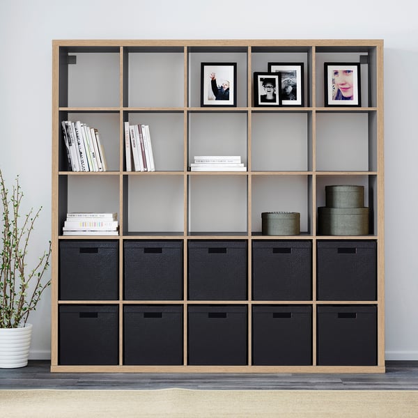 KALLAX shelving unit with boxes, books, photos, and plant.