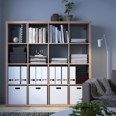 KALLAX shelf with books, bins, decor, & plants.