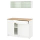 Modern white kitchen setup with oak countertop, glass cabinet, and storage drawers.