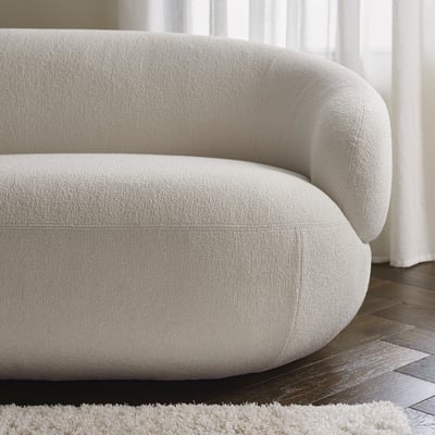 Modern cream-colored sofa, soft texture, plush cushions, designed for comfort and style.