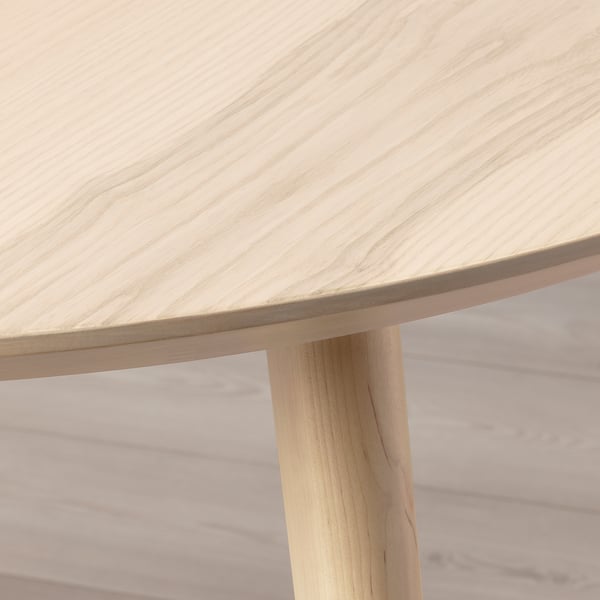 LISABO table close-up: smooth ash veneer top, sturdy solid birch leg, natural wood finish.