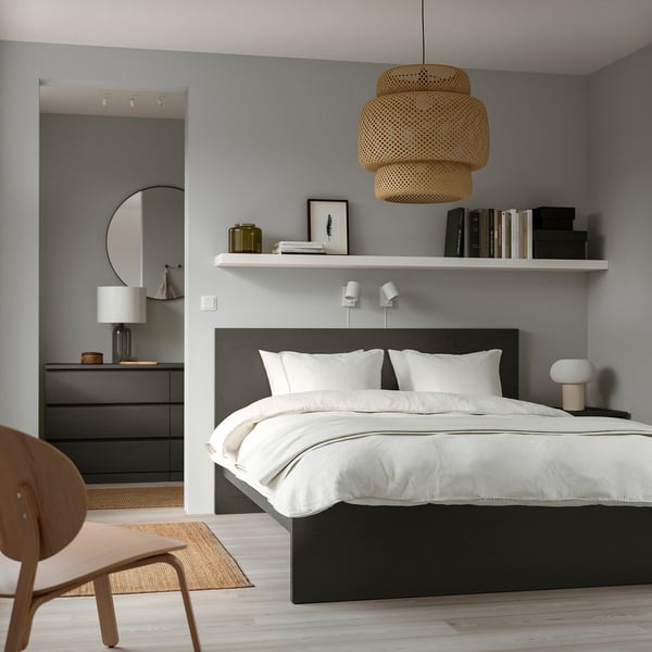 Modern bedroom: MALM bed, white linens, wood chair, round light, shelves, lamp, mirror. Grey walls, wooden floor.