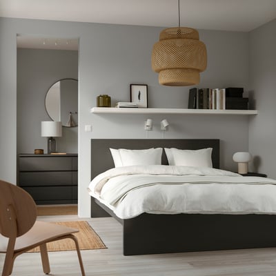 Modern bedroom with MALM bed, white comforter, wooden chair, round hanging lamp, sleek dresser.