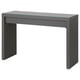 A grey MALM dressing table by IKEA, featuring a glass top, a single drawer with a felt lining, and sturdy legs.