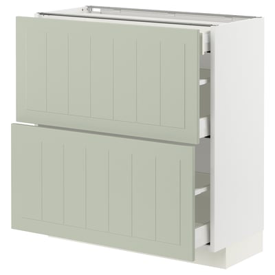 Modern kitchen unit in light green with two drawers and two cabinet doors, sleek and minimalist design.