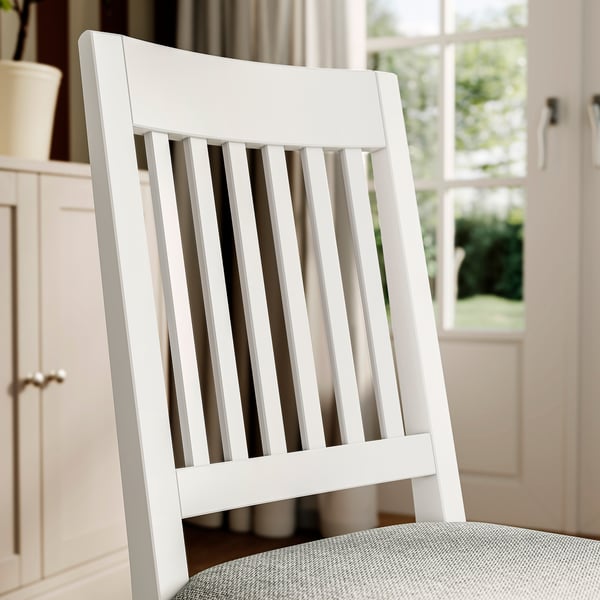 White NÄSINGE high-back chair with slatted design. Quality solid wood, comfy seat with removable cover. Sit comfortably during long dinners.