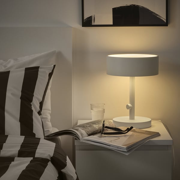 Modern bedroom with NYMÅNE lamp & striped pillows.