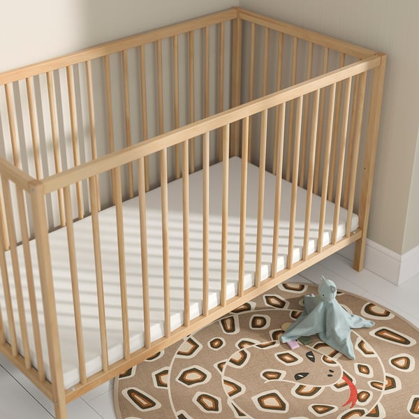 PELLEPLUTT mattress, beige, fits snugly in wooden crib, slightly smaller, soft surface.