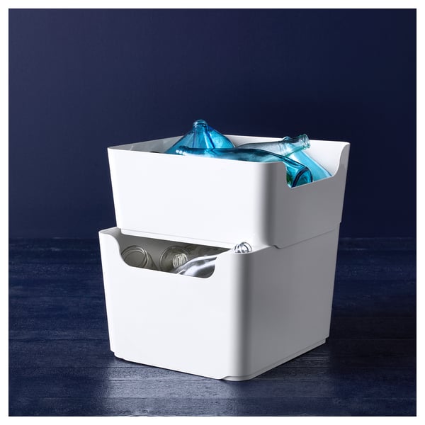 Stack of white recycled plastic boxes with blue bottles and jars.