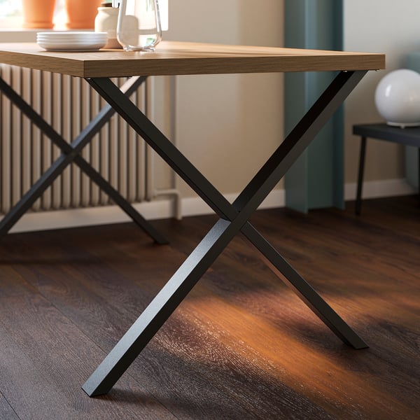 Modern dining table with black metal legs and wooden top. Sturdy construction, clean lines, minimalist design.