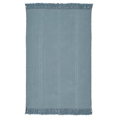 A light blue rectangular cotton rug with fringe on both ends, ideal for various floors.