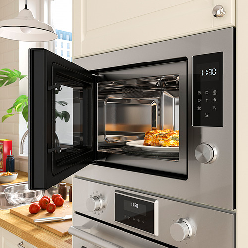 Modern microwave with digital display and digital timer showing 1:38. Food inside, doors open.
