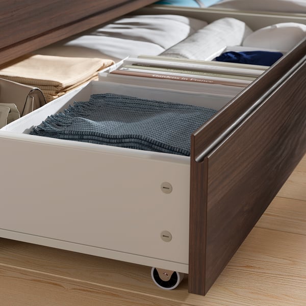 Under-bed storage drawers on casters for easy access.