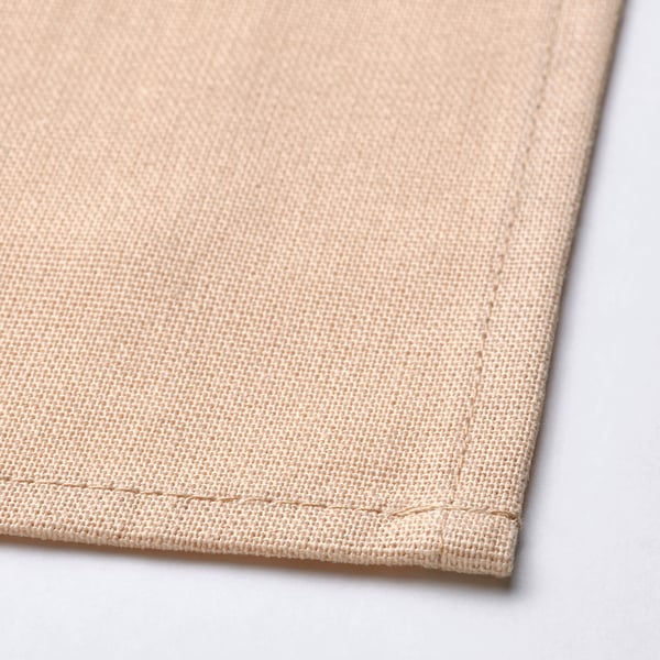 Beige cotton napkin, neatly folded, showcasing fine weave and stitching, highlighting quality.