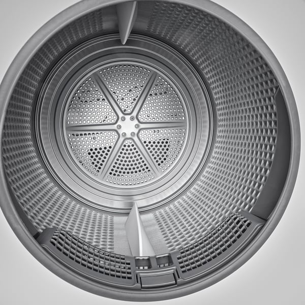 Top view of dryers perforated metal drum and lifters for even clothes movement.