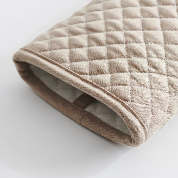Folded quilted pillow on white surface. Soft, diamond-patterned fabric with keen stitching.