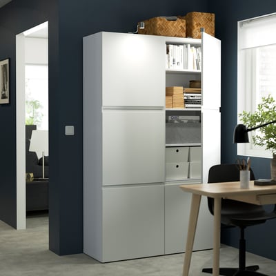 Modern storage unit with handles, books, hidden storage, and desk with chair.