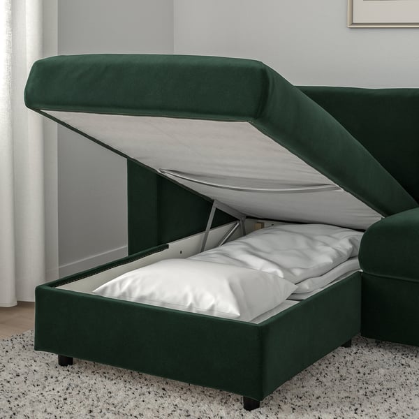 Green VIMLE sofa bed with storage open, revealing mattress and white linens.
