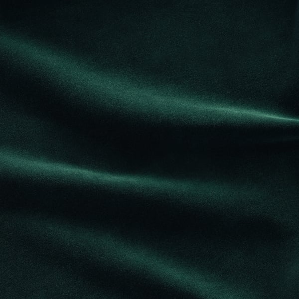 Soft, dark green velvet sofa with a plush texture, showcasing elegant curves and a luxurious feel.