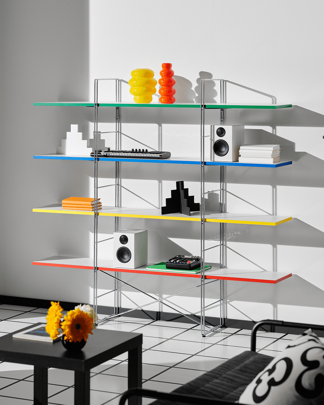 The BYAKORRE open shelving unit with a metal frame and coloured shelves, in a white roomset.
