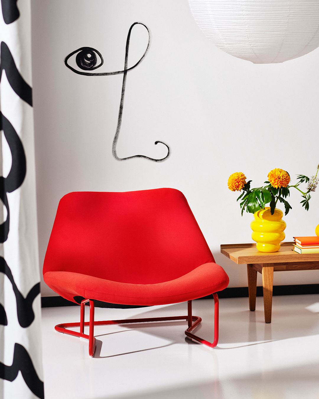 A white roomset with a table and pendant lamp appears behind the cutout of a red SOTENÄS chair.