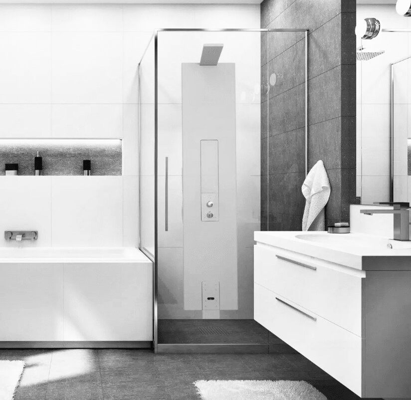 A black and white image of a bathroom showing a vanity unit, the edge of a bathtub and a shower in focus.