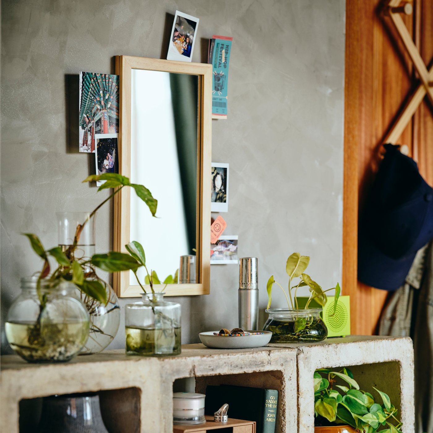 A mirror, shelf and decorative objects displayed in a home interior.