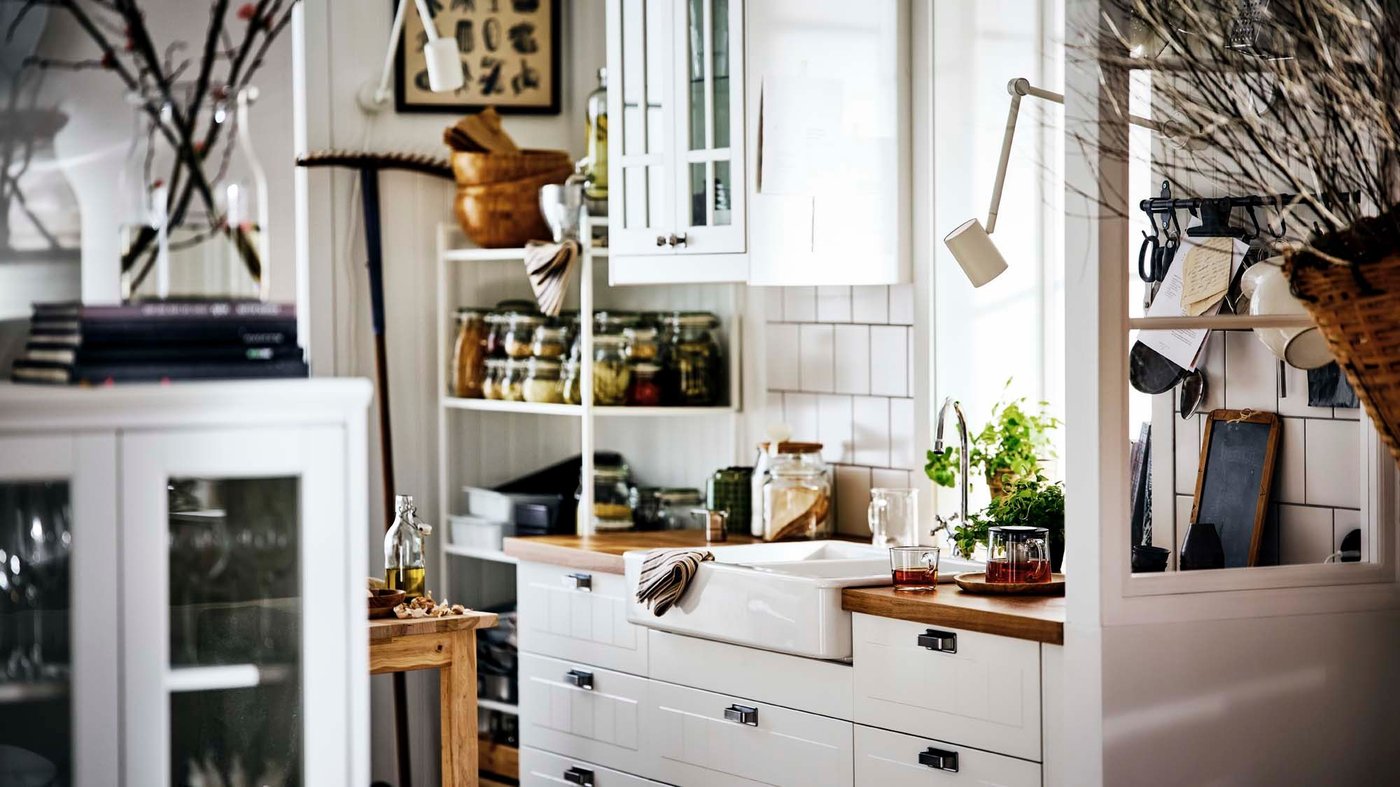 The traditional white STENSUND kitchen with open shelves filled and a wooden worktop.
