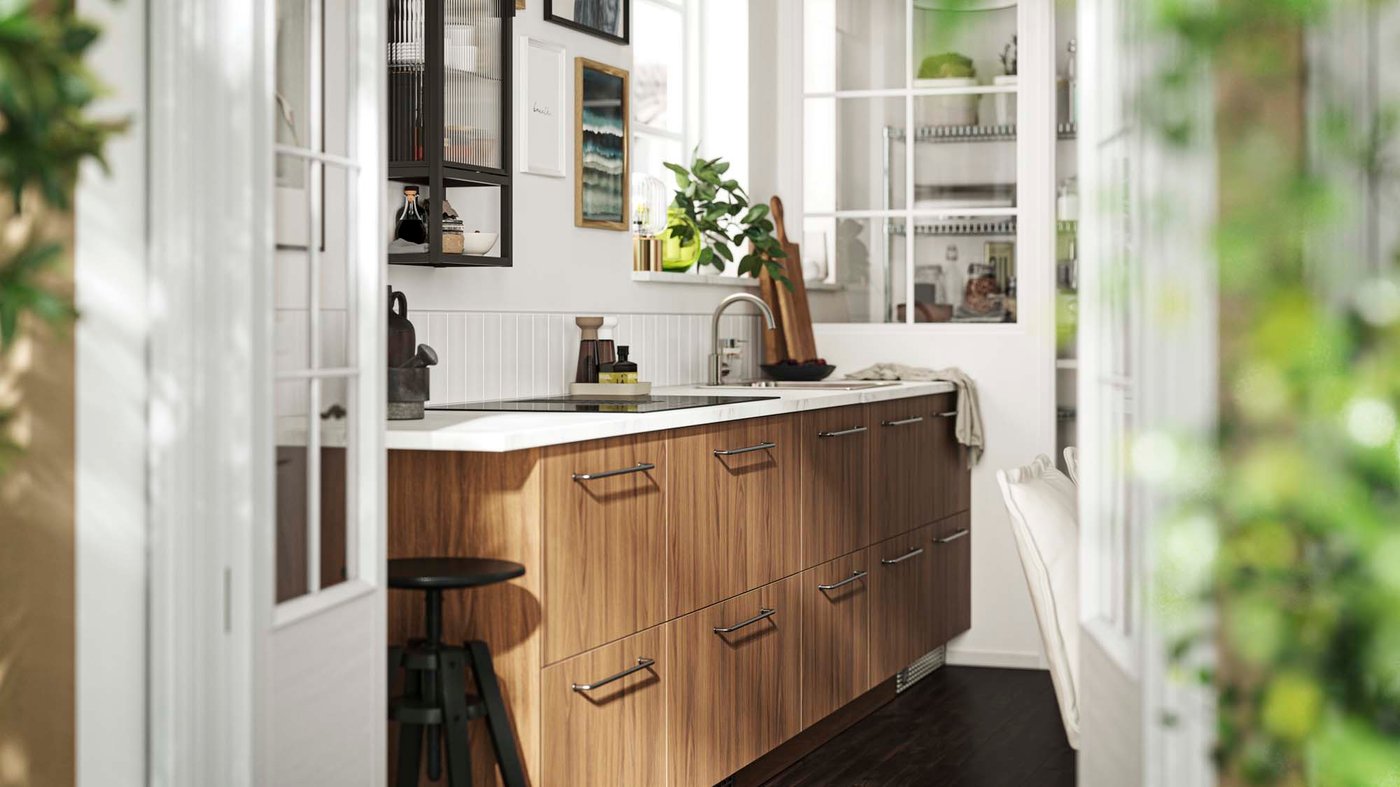 A white kitchen with wooden lower cabinetry and art on the wall.
