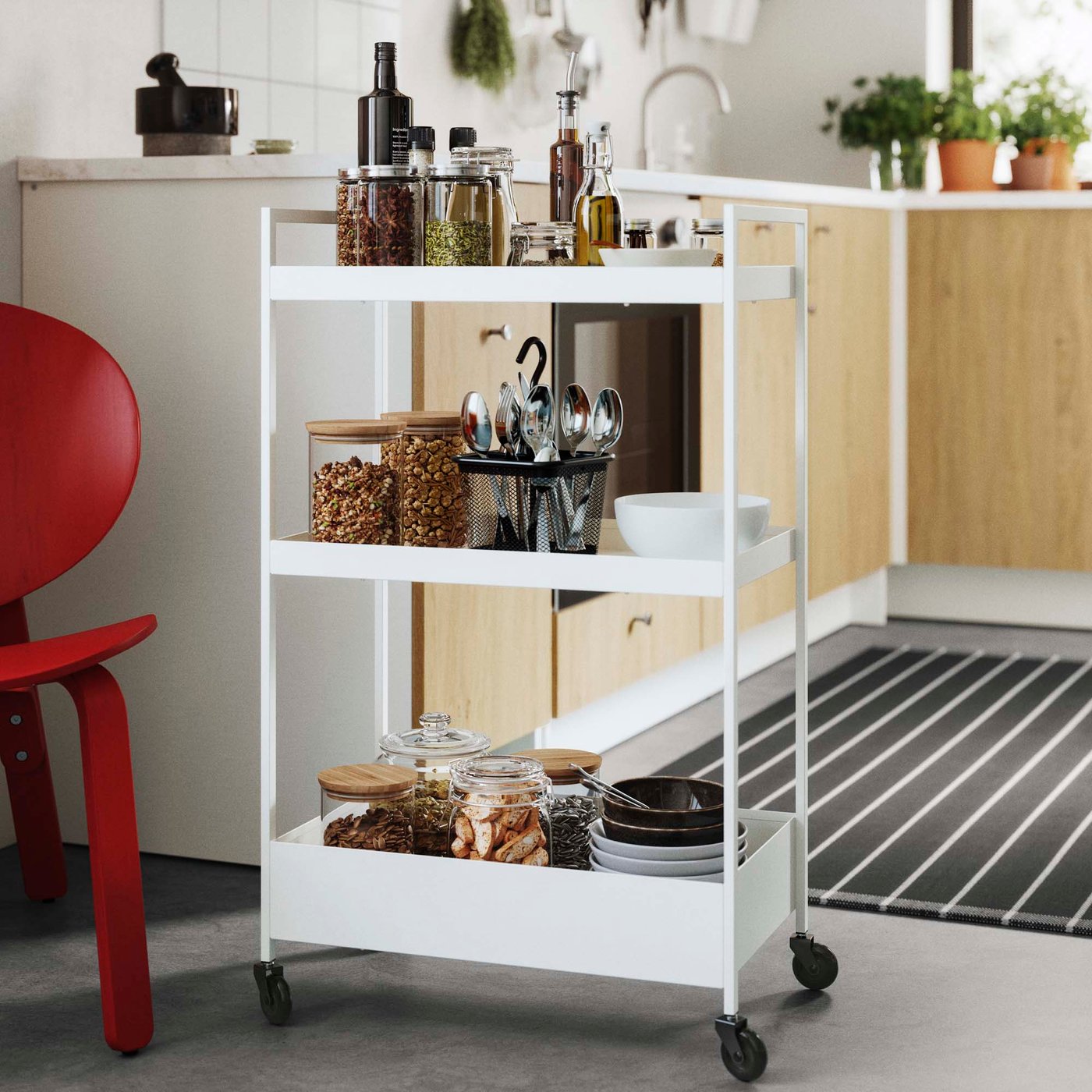 A white trolley laden with food in a white and wood kitchen.
