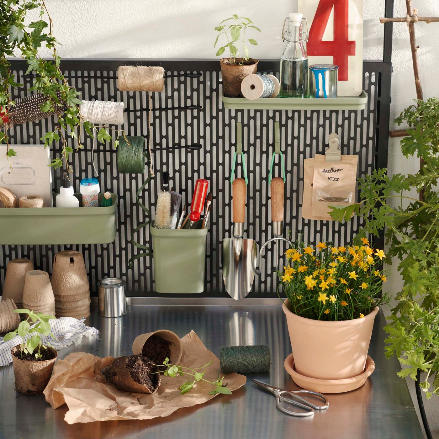 A black back panel with hooks and shelving used for storing garden equipment outside.