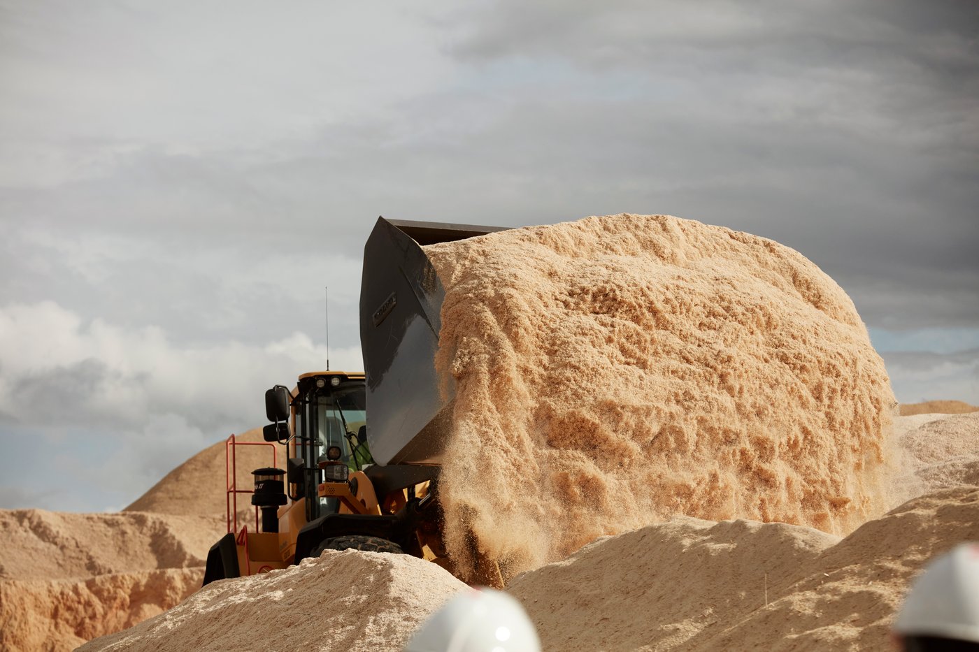 A truck offloads a load of processed wood.