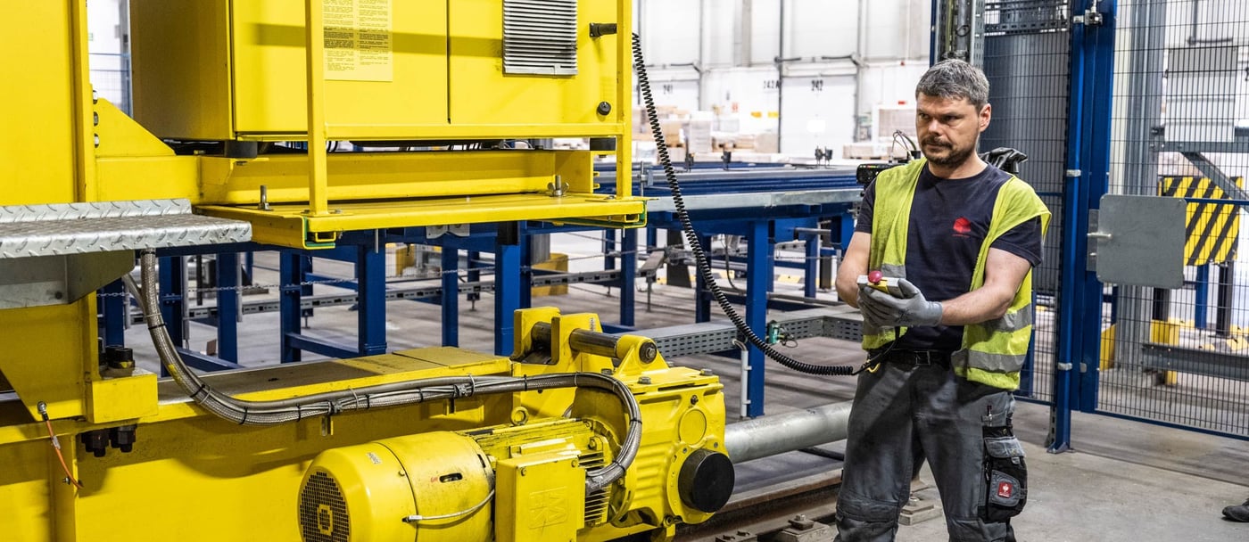 A man operates a machine in a factory setting.