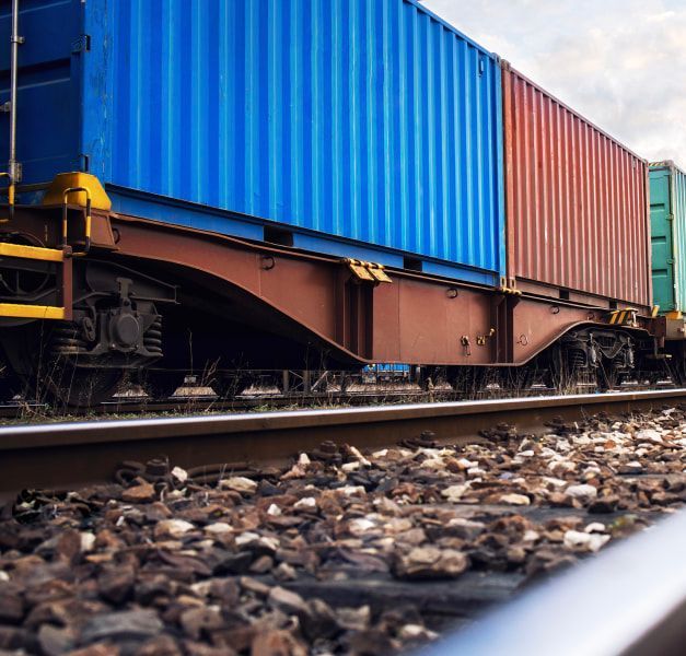 A freight train with colourful containers passing on a train track. 