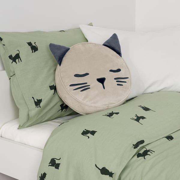 Light green bedding with black cat patterns and a plush cat pillow featuring a back pocket, designed for children aged 3+.