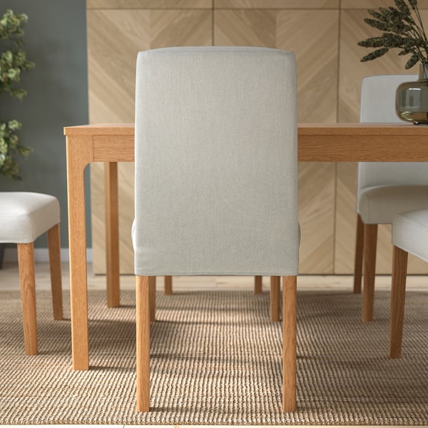 Modern dining setup with light grey upholstered chair, wooden legs, and table, perfect for comfortable meals.