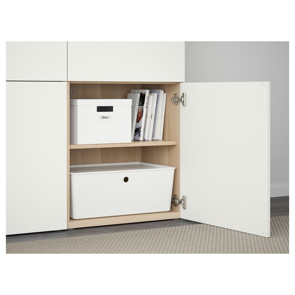 White cabinet with wooden shelves, holding books and storage boxes.