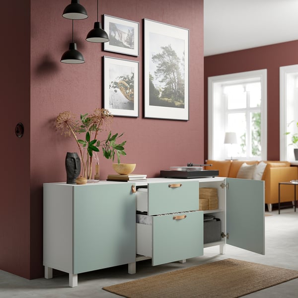 A light blue and white BESTÅ sideboard with open doors revealing shelves and drawers, showcasing storage and organisation.