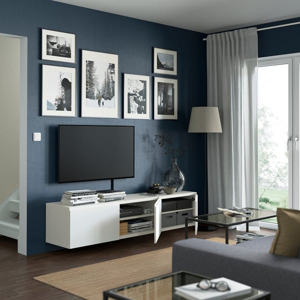 Modern living room with BESTÅ tv bench, shelves, cable management, and soft-close doors. Tv, art, large window with curtains.