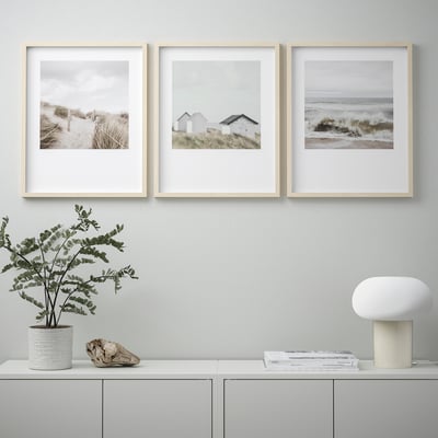 Three coastal photos in frames, decor on shelf