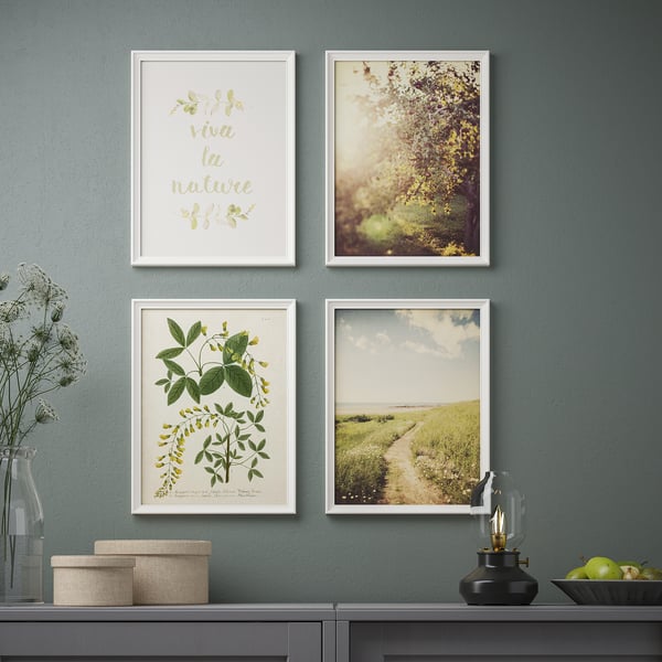 Four nature-themed framed artworks hang on a grey wall, complemented by a side table with decorative items.